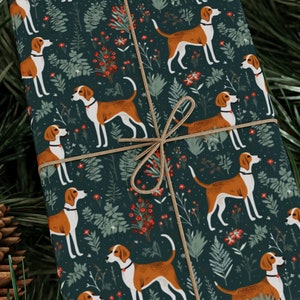 May include: A gift box wrapped in dark blue wrapping paper with a repeating pattern of brown and white dogs, green leaves, and red berries. The box is tied with a brown twine bow.