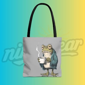 May include: A gray tote bag featuring a vintage illustration of a frog in a blue robe holding a steaming white mug. The bag has black handles and a gradient background of blue, yellow, and green.