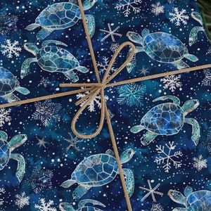 Può includere: Carta da regalo blu e bianca con un motivo ripetitivo di tartarughe marine e fiocchi di neve. La carta è legata con un fiocco di spago marrone.