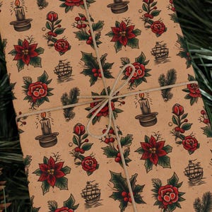May include: Kraft paper gift wrap with a repeating pattern of red roses, poinsettias, holly, candles, and ships. The paper is tied with a natural twine bow. The overall theme is a vintage Christmas design.