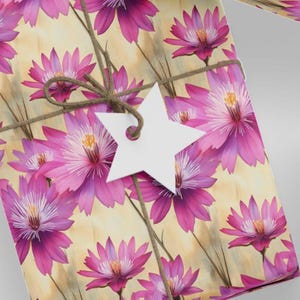 Puede incluir: Papel de regalo floral rosa y blanco con una etiqueta blanca en forma de estrella atada con cuerda.