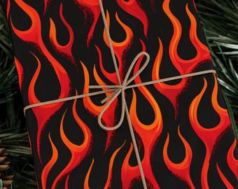 May include: Gift wrapped in black paper with a vibrant flame pattern in shades of red and orange. A natural twine bow adds a rustic touch. The wrapping paper is suitable for various occasions.