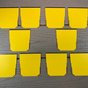 May include: Ten yellow sticky notes with black borders, arranged in two rows of five on a woodgrain surface.
