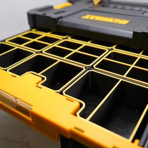 May include: A black and yellow tool organiser with a drawer that has multiple compartments. The drawer is open and the compartments are empty.
