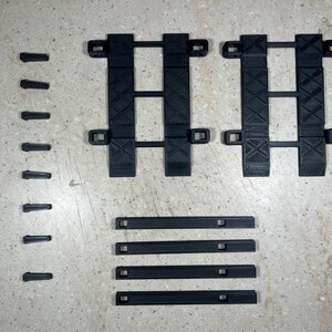 Puede incluir: Un conjunto de v&iacute;as de pl&aacute;stico negro para un tren de juguete. El conjunto incluye v&iacute;as rectas y v&iacute;as curvas.