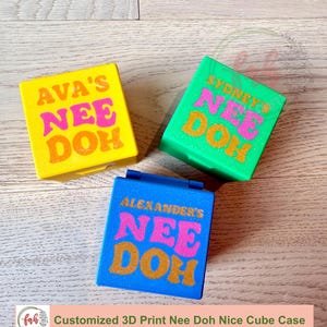 May include: Three square plastic cases in yellow, green, and blue. Each case features glittery text on the lid. The yellow case reads AVA'S NEE DOH, the green case reads SYDNEY'S NEE DOH, and the blue case reads ALEXANDER'S NEE DOH in pink and gold.