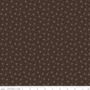 May include: A brown fabric with a repeating pattern of small white dots and tan leaf designs.