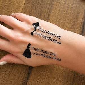 May include: Two black temporary tattoos applied to the skin. One features a mermaid silhouette with the text If Lost Please Call: (+44) 789 XXX XX XX. The other shows a princess silhouette with the text If Lost Please Call: (+44) 789 XXX XX XX.
