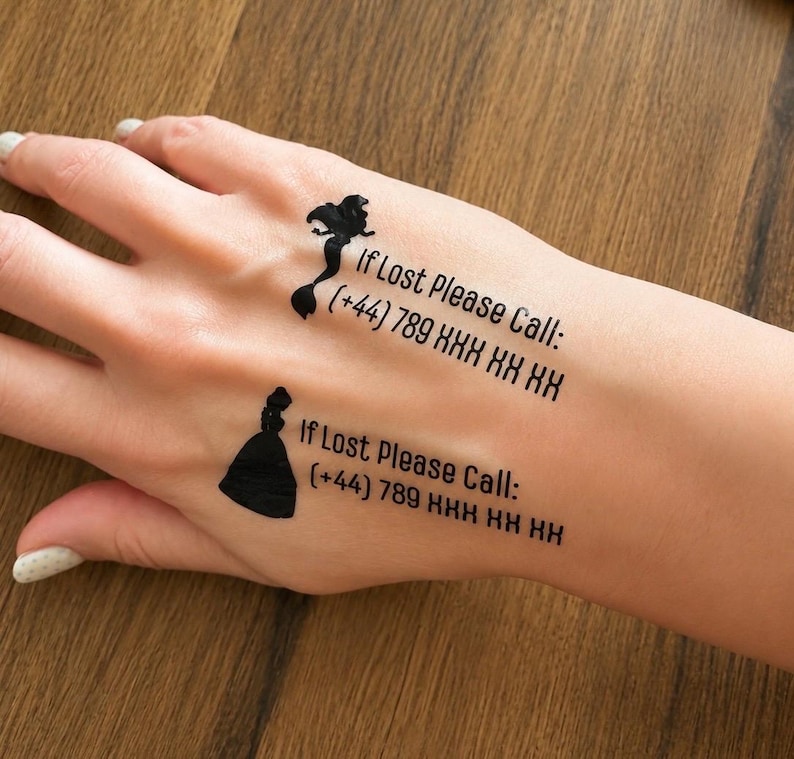 May include: Two black temporary tattoos applied to the skin. One features a mermaid silhouette with the text If Lost Please Call: (+44) 789 XXX XX XX. The other shows a princess silhouette with the text If Lost Please Call: (+44) 789 XXX XX XX.