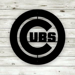 May include: Black metal sign with a circle and a "C" inside. The word "CUBS" is written across the center of the "C".
