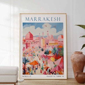 May include: A vintage travel poster for Marrakesh, Morocco. The poster features a colorful illustration of the city's architecture and a bustling marketplace. The text "MARRAKESH" is in a bold blue font at the top of the poster. The coordinates "31.6225&deg; N, 7.9988&deg; W" are printed at the bottom of the poster.