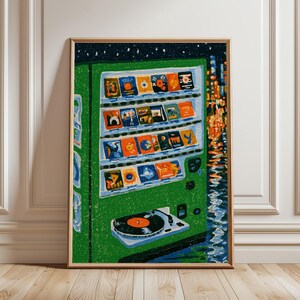 May include: A vertical art print featuring a green vending machine stocked with various colorful square items. Below the shelves, a black vinyl record sits on a white turntable. The background depicts a dark night scene with orange lights.