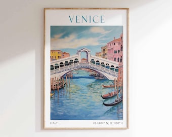 May include: A framed art print featuring a watercolor painting of Venice, Italy. The Rialto Bridge is the focal point, with gondolas on the blue water. The word "VENICE" is at the top, with "ITALY" and coordinates at the bottom.