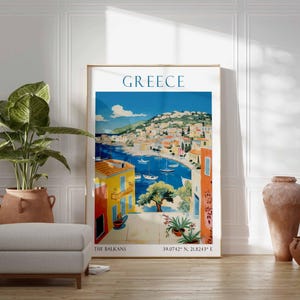 May include: A vintage travel poster featuring a colorful illustration of a coastal town in Greece. The poster has the text "GREECE" in large blue letters at the top and "THE BALKANS" and coordinates at the bottom.