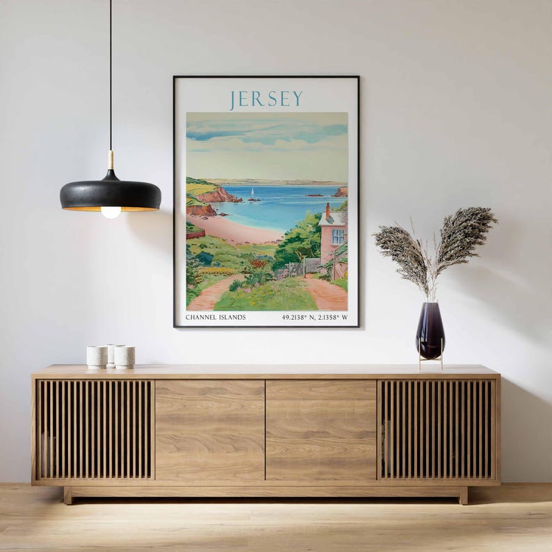May include: A framed poster of Jersey, Channel Islands, showing a coastal scene with a sandy beach, turquoise sea, and a pink house. The poster has the word "JERSEY" at the top and coordinates at the bottom.