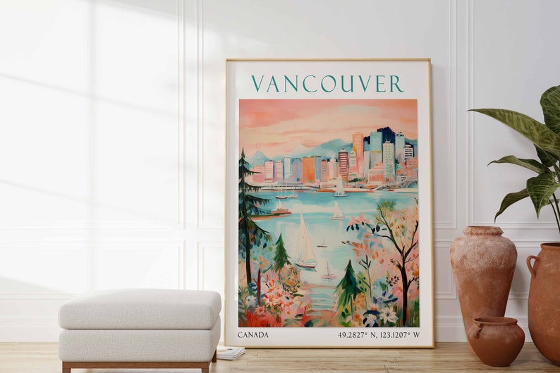 May include: A vintage travel poster featuring a colorful illustration of the Vancouver skyline with sailboats in the water. The poster has the text "VANCOUVER" in teal blue and "CANADA" and coordinates in black at the bottom.