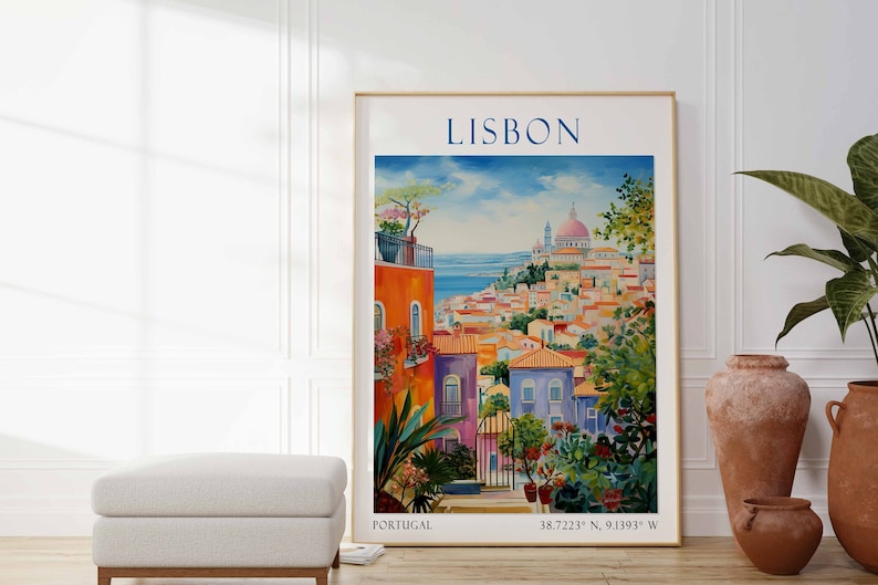 May include: A colorful painting of Lisbon, Portugal, with a view of the city and the Tagus River. The painting features a bright blue sky, white clouds, and a variety of colorful buildings. The text "LISBON" is at the top of the painting, and the coordinates "38.7223&deg; N, 9.1393&deg; W" are at the bottom.