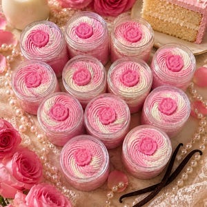 May include: A collection of eleven clear plastic jars filled with swirled pink and white whipped cream, each topped with a solid pink rose-shaped accent. The jars are arranged in a cluster, showcasing the textured cream and the decorative rose topper.