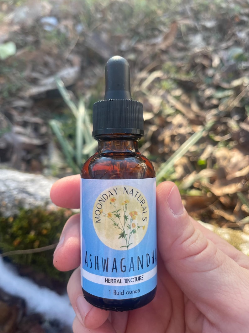 May include: A brown glass bottle with a black dropper top. The label reads "Moonday Naturals Ashwagandha Herbal Tincture 1 fluid ounce".