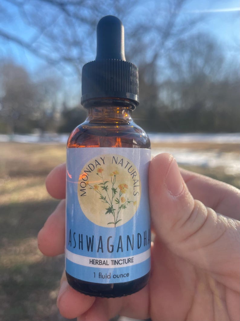 May include: A brown glass bottle with a dropper top and a blue and white label that says "Moonday Naturals Ashwagandha Herbal Tincture 1 fluid ounce".