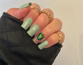 Unhas postiças verde-sálvia com um design fofo de abacate.