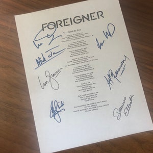 Könnte beinhalten: Ein weißes Blatt Papier mit den Texten des Songs "Cold as Ice" der Band Foreigner. Die Texte sind von allen vier Mitgliedern der Band signiert: Mick Jones, Ian McDonald, Al Greenwood und Dennis Elliott.
