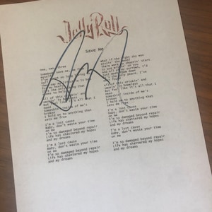 May include: A handwritten lyric sheet for the song "Save Me" by the artist "Jelly Roll". The lyrics are written in black ink on white paper. The lyrics include the lines "I'm a lost cause" and "Baby, don't waste your time on me".
