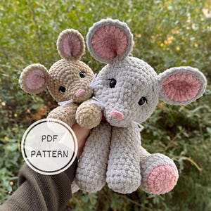 Puede incluir: Dos peluches de ratón de ganchillo. Uno es marrón claro, el otro gris. Ambos tienen orejas internas rosas, ojos negros y bigotes blancos. El ratón gris es más grande y tiene rosa en los pies. La imagen incluye un gráfico "PDF PATTERN".