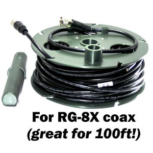 May include: A black coaxial cable wound around a green plastic spool, accompanied by a separate cylindrical green component. The text reads: For RG-8X coax (great for 100ft!). The cable features metallic connectors at both ends for secure attachment.