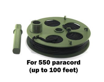 May include: An olive green plastic spool wound with black 550 paracord and a separate matching olive green handle. The text below reads: For 550 paracord (up to 100 feet). The spool features four circular cutouts and small integrated hooks.