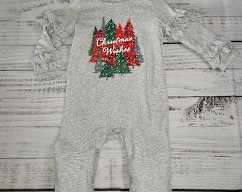 May include: Gray long-sleeve jumpsuit with a Christmas tree design and the text "Christmas Wishes". The jumpsuit has red and green plaid trim and ruffles on the sleeves and legs.