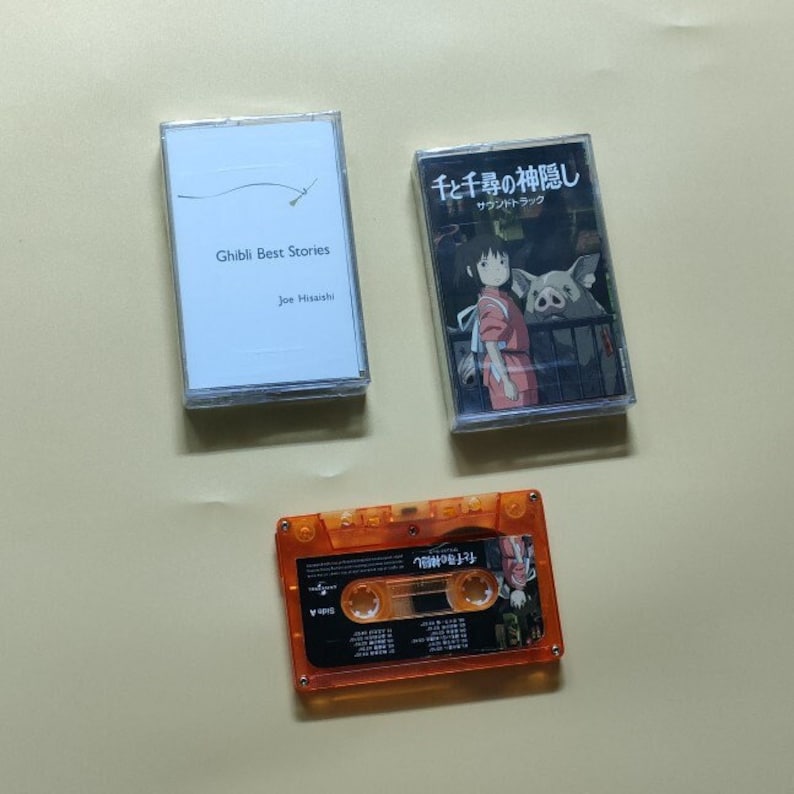 Pu&ograve; includere: Tre cassette audio, due con custodie bianche e una con una custodia arancione trasparente. Le custodie bianche hanno testo e immagini in giapponese. La custodia arancione ha il testo "Totoro" in giapponese.