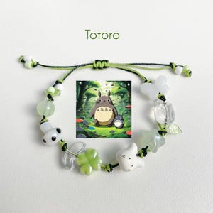 Puede incluir: Un brazalete de charms verde y blanco con un charm de Totoro. El charm representa a Totoro y a un personaje m&aacute;s peque&ntilde;o de la pel&iacute;cula Mi vecino Totoro. El brazalete tambi&eacute;n incluye cuentas verdes y blancas, un charm de mariposa y un charm de hoja.