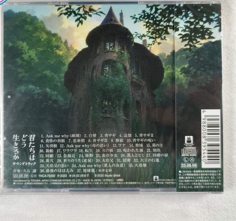 May include: CD case with a green and brown illustration of a building with a tower. The text on the back of the case reads "Ask me why (疎開) 2. 白壁 3. 青サギ 4. 追憶 5. 青サギⅡ 6. 黄昏の羽根 7. 思春期 8. 青サギⅢ 9. 静寂 10. 青サギの呪い 11. 矢羽根 12. Ask me why (母の思い) 13.ワナ 14. 聖域 15.墓の主 16.箱船 17.ワラワラ 18. 転生 19. 火の雨 20.呪われた海21. 別れ 22. 23. 急接近 24.陽動25、炎の少女 26、人とヒミ27、回線の 28.巣穴 29, 折りのうた(産屋) 30.大伯父 31.隱密 32、大王の行進 33.大伯父の思い 34. Ask me why (萬人の決意)35、大崩壞 36.最後のほほえみ 37,地球儀/米津玄師 23.08.09 TKCA-75200 2023 24.02.08まで 2023 Studio Ghibl manufactured by TOKUMA JAPAN COMMUNICATIONS CO.LTD/MADE IN JAPAN/STEREO".