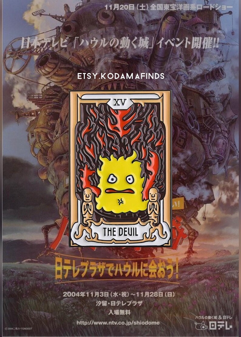 May include: A gold-colored enamel pin featuring a yellow cartoon character with a red and black flame design. The pin is a depiction of the Devil card from a tarot deck. The text "XV THE DEUIL" is printed on the pin.