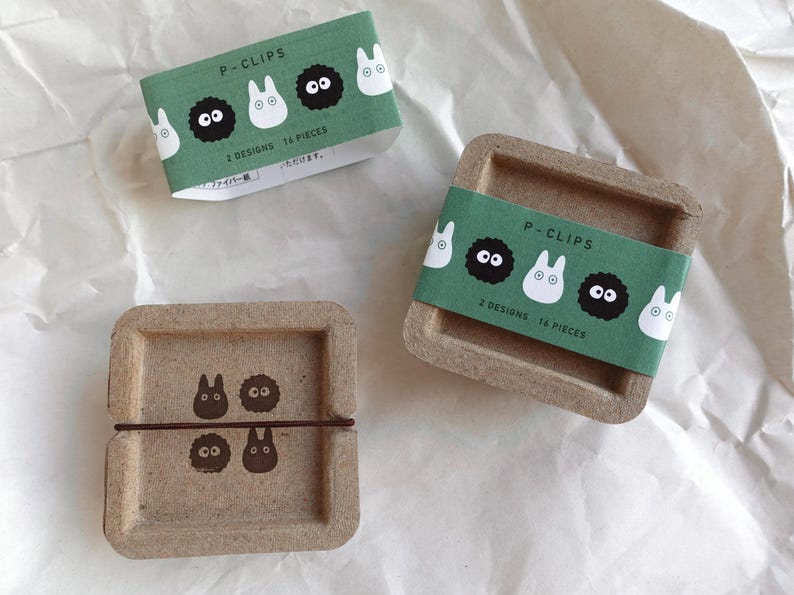 May include: Two cardboard boxes with green and white labels that say "P-Clips" and feature cartoon characters. The boxes contain 14 and 16 paper clips.