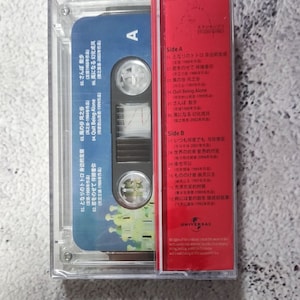 Pu&ograve; includere: Una custodia per cassette rossa con il titolo "Studio Ghibli" e un elenco di canzoni di vari film di Studio Ghibli, tra cui "Il mio vicino Totoro", "Il castello nel cielo", "Kiki consegna a domicilio" e "La principessa Mononoke".