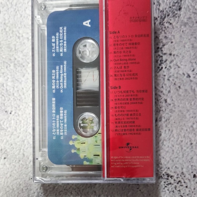 Pu&ograve; includere: Una custodia per cassette rossa con il titolo "Studio Ghibli" e un elenco di canzoni di vari film di Studio Ghibli, tra cui "Il mio vicino Totoro", "Il castello nel cielo", "Kiki consegna a domicilio" e "La principessa Mononoke".