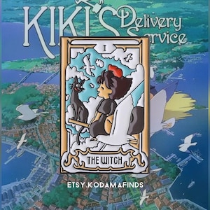 May include: A colorful enamel pin featuring Kiki from the movie Kiki's Delivery Service. The pin depicts Kiki flying on her broomstick with her black cat Jiji. The pin is a tarot card style design with the text "The Witch" and "I" in the top corner. The pin is a collectible item for fans of the movie.