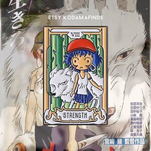 May include: A white enamel pin featuring a cartoon character from the movie Princess Mononoke. The character is a young girl with blue hair and a red hat. She is standing next to a white wolf. The pin is a tarot card design with the number VIII and the word STRENGTH. The background is green and white.