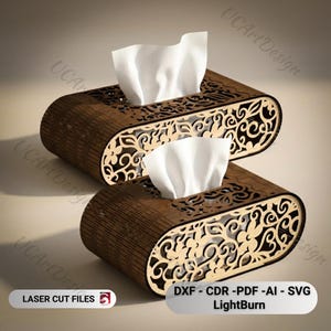 Op de afbeelding: Twee houten tissueboxen met ingewikkelde bloemenpatronen. Elke doos, gemaakt van donkerbruin hout, heeft een rechthoekige vorm met afgeronde randen en bevat witte tissues. De tekst "LASER CUT FILES" en "DXF - CDR -PDF -AI - SVG LightBurn" zijn zichtbaar.
