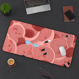 Op de afbeelding: Een roze en witte muismat met een ontwerp van cartoonfiguren. De figuren zijn roze en wit en hebben grote ogen en glimlachen. De muismat is rechthoekig en heeft een glad oppervlak.