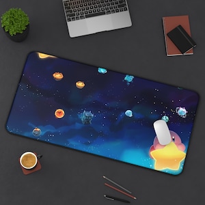 May include: A large rectangular mousepad featuring a vibrant space-themed design with planets and stars. A cartoon character is holding a large yellow star. A white computer mouse rests on the pad. A laptop, coffee cup, and notepad are also visible.