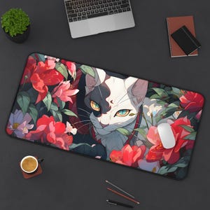 Op de afbeelding: Een zwart-witte kat met groene ogen kijkt uit achter een levendig rood en groen bloemenontwerp. De kat wordt omringd door weelderig groen en rode bloemen. Het ontwerp is gedrukt op een zwarte muismat.