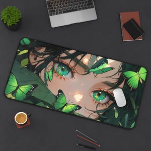 May include: A rectangular mouse mat with an anime-style illustration of eyes with green irises, surrounded by green butterflies and foliage. A white mouse is on the right. The mat is black.