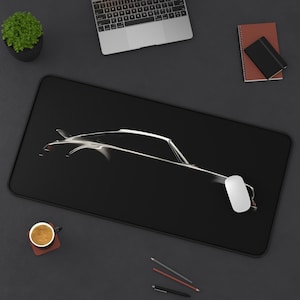 May include: A black mouse mat with a silhouette of a silver sports car. The car is facing the right side of the image. A white computer mouse is on the mouse mat.