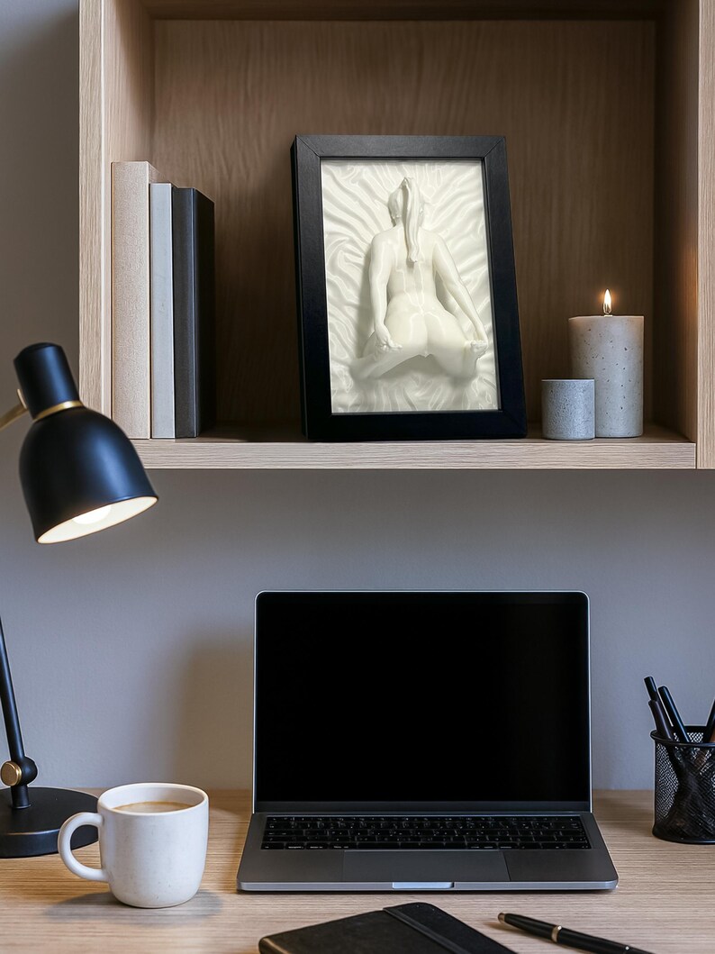 White erotic art sculpture naked woman on desk with lamp and laptop