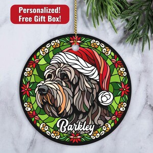 May include: A round Christmas ornament featuring a stained glass style illustration of a dog wearing a Santa hat. The dog's name, "Barkley", is written in a decorative font below the dog's head.