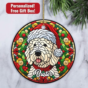 May include: A white dog wearing a red Santa hat and a red scarf with a stained glass design. The dog's name is "Buster" and is surrounded by holly and berries.