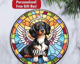 May include: A stained glass style ornament featuring a dachshund with angel wings. The dog is black, brown, and white with a halo above its head. The text "Max" is written below the dog.